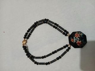 Collana con ciondolo floreale nero e rosso