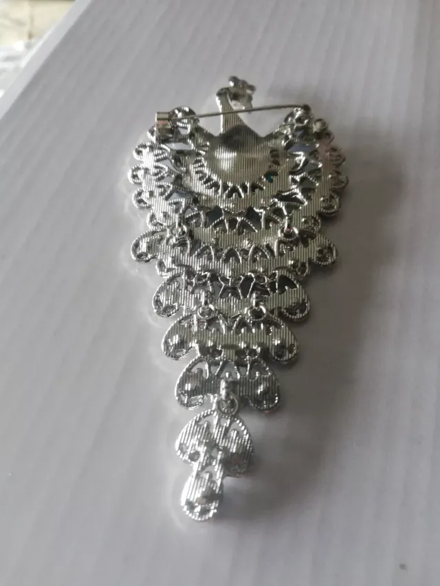 Broche de pavão com pedras azuis