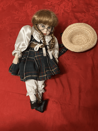 Bambola vintage ragazzina seduta sedia vimini