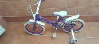 Bicicleta niña morada con ruedines