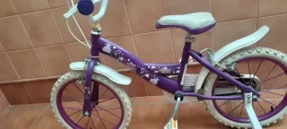 Bicicleta niña morada con ruedines