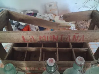 Caja antigua de madera con botellas de cristal