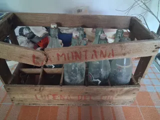 Caja antigua de madera con botellas de cristal