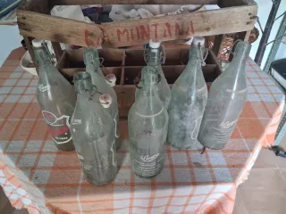 Caja antigua de madera con botellas de cristal