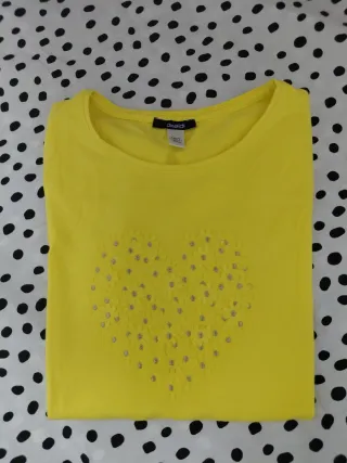 Camiseta amarilla con corazón de flores. 