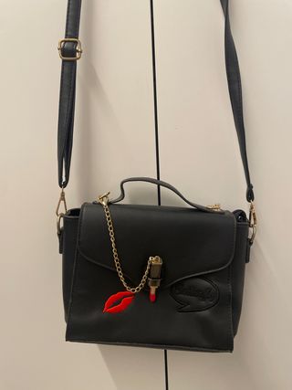Bolso negro con adorno de labios y pintalabios