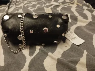 Bolso negro con cadena y tachuelas plateadas