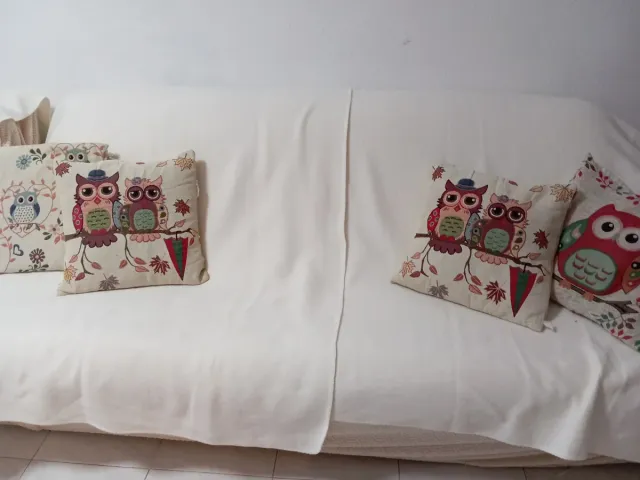 Sofá blanco con cojines de búhos