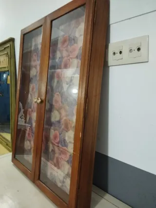 Vitrina pequeña de madera con puertas de cristal. 