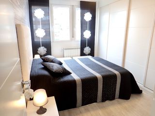 Colcha de cama negra y plateada con 2 cojines. 
