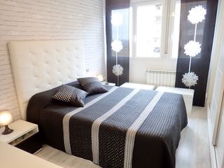 Colcha de cama negra y plateada con 2 cojines. 
