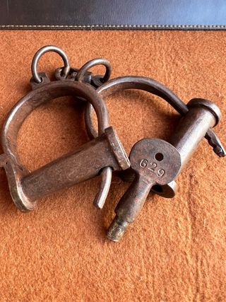 Antiche manette in ferro battuto con chiave