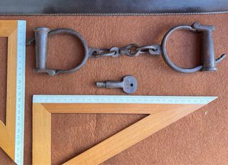 Antiche manette in ferro battuto con chiave