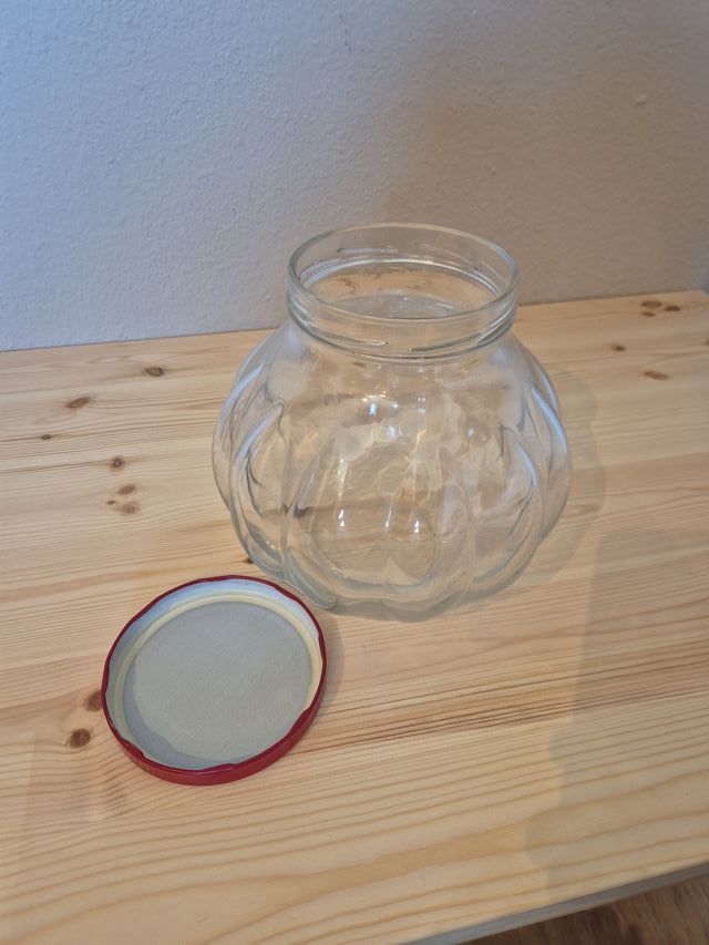 Antico barattolo in vetro con coperchio rosso