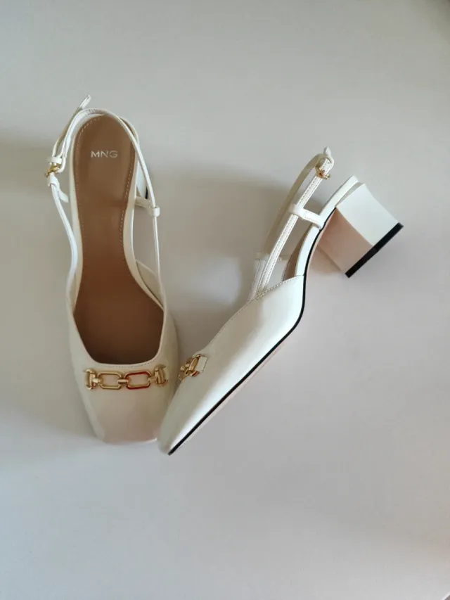 Zapatos MNG blancos con cadena dorada.