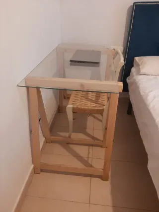 Mesa de cristal con caballetes de madera