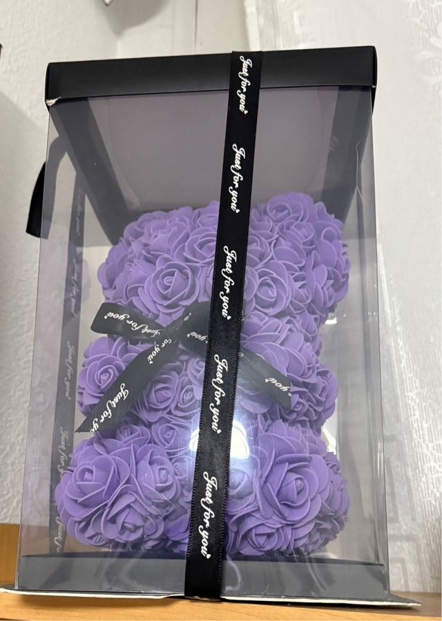 Precioso osito hecho de pétalos morados en su caja