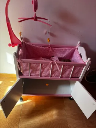Cuna de muñecas rosa con móvil