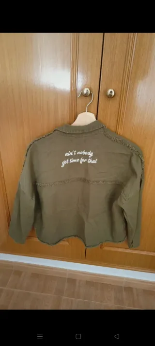 Chaqueta verde militar con mensaje en la espalda
