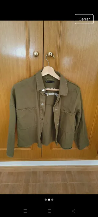 Chaqueta verde militar con mensaje en la espalda
