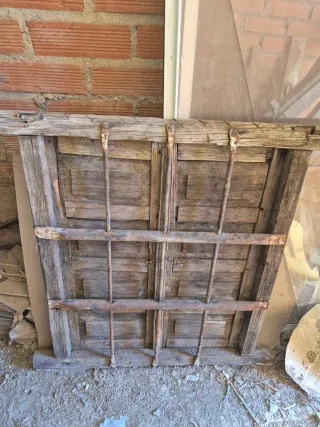 Ventana antigua de madera con barrotes