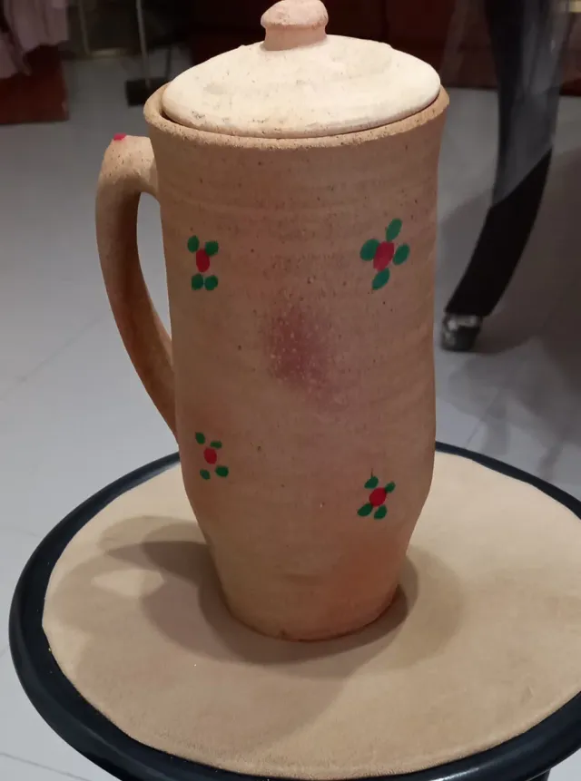 Jarra de arcilla con tapa y flores