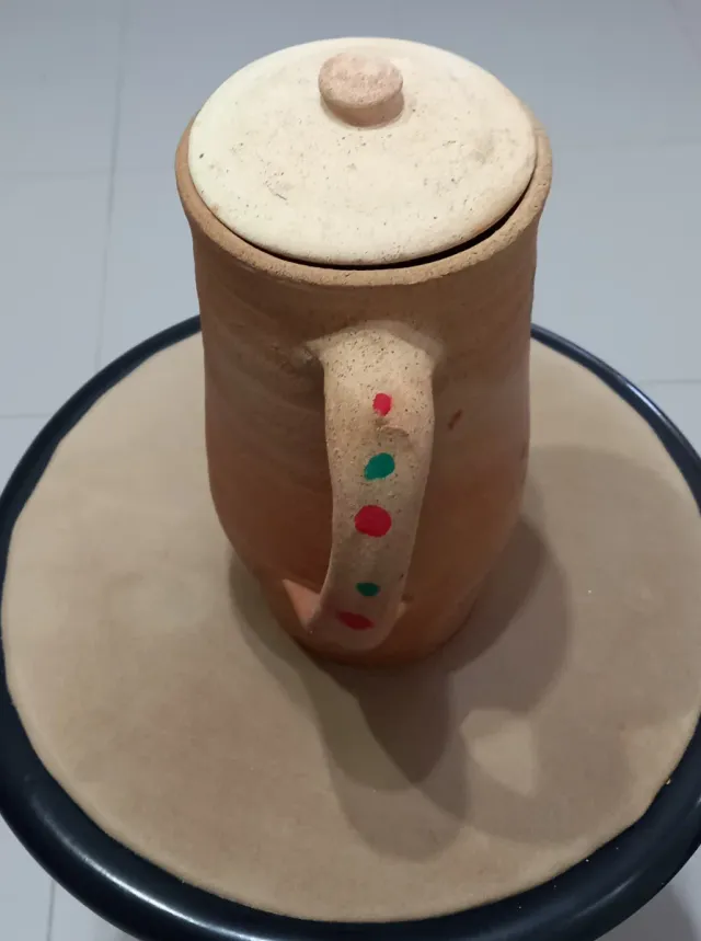 Jarra de arcilla con tapa y flores