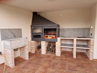 Barbacoa de obra con horno y leñero