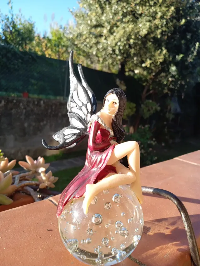 Fata seduta su sfera di vetro