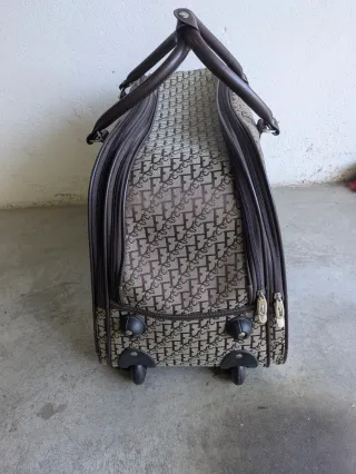 Bolso de viaje beige y marrón con ruedas.