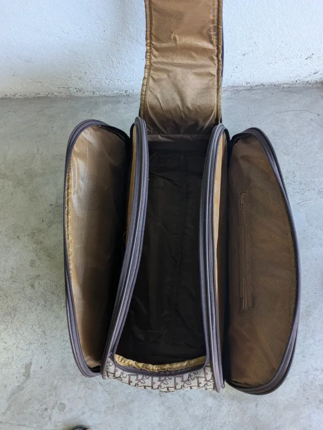 Bolso de viaje beige y marrón con ruedas.