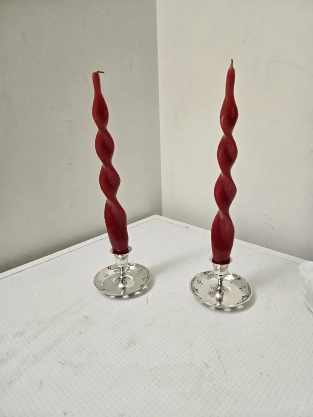 Candeleros plateados con velas rojas