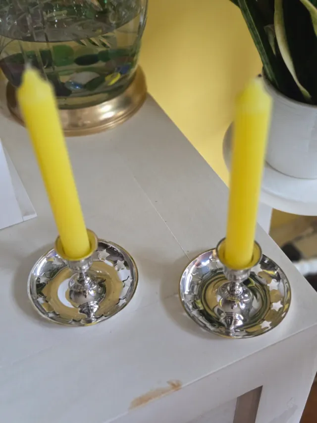 Candeleros plateados con velas rojas