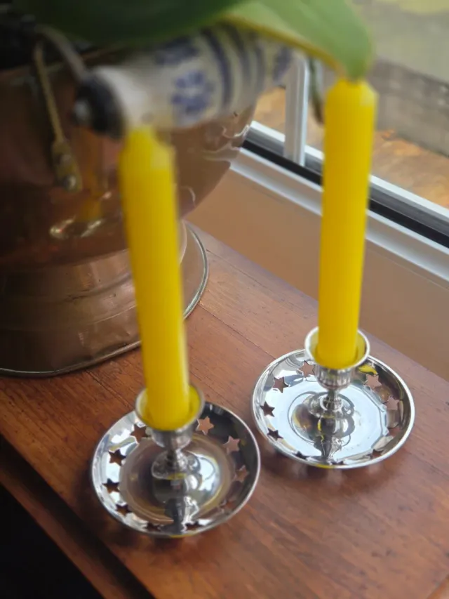 Candeleros plateados con velas rojas