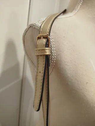 Elegante bolso dorado con flecos