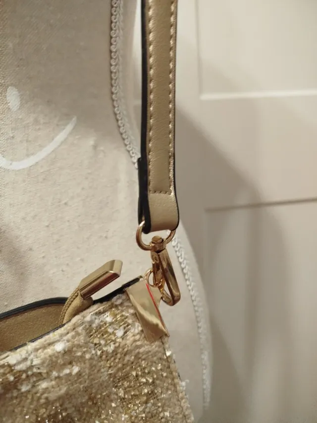 Elegante bolso dorado con flecos