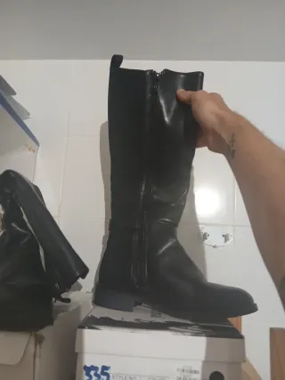 Botas altas negras con hebilla dorada