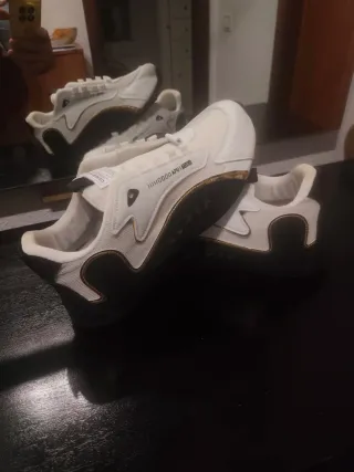 Zapatillas deportivas blancas y doradas