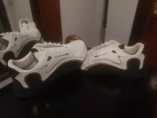 Zapatillas deportivas blancas y doradas