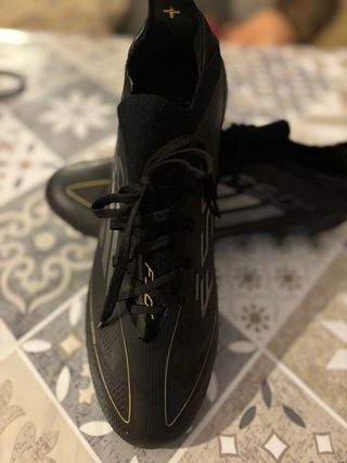 Botas de fútbol negras y doradas