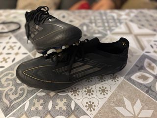 Botas de fútbol negras y doradas