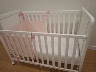 Cuna de bebé blanca con estrellitas rosas