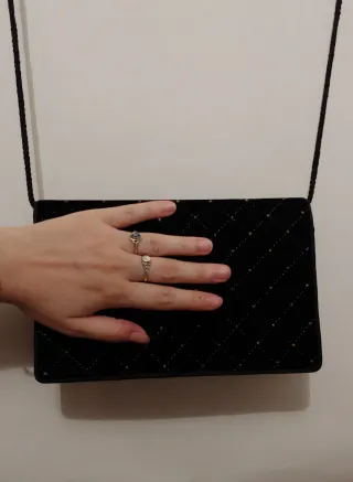 Clutch de terciopelo negro con tachuelas doradas