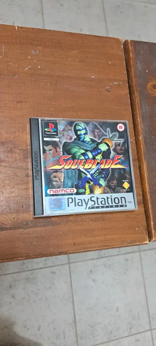 Consola PS1 cinzenta com 2 controlos e 8 jogos. Conjunto.