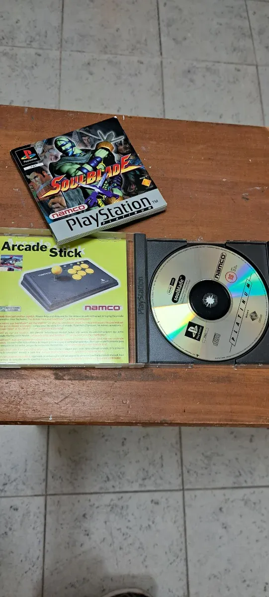 Consola PS1 cinzenta com 2 controlos e 8 jogos. Conjunto.