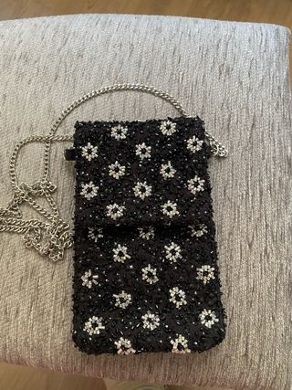 Bolso móvil negro con flores plateadas