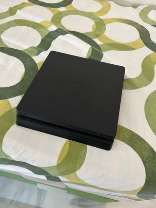PS4 slim con un mando y puerto de carga para mando