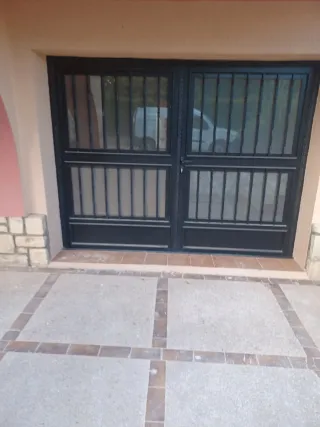 Puerta de hierro con rejas y mosquitera