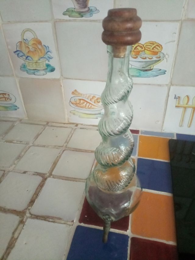 Bottiglia antica in vetro con rubinetto