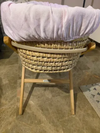 Moisés de mimbre con soporte de madera.